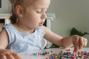 İplik ve renkli boncuklardan bilezik yapma süreci, hobi ya da eğlence kavramı