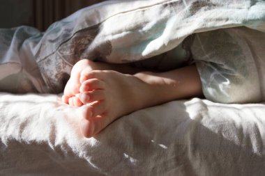 Ayaklarını yatağın üzerinde hafif bir battaniyenin altına koy. Sağlıklı yaşam kavramı