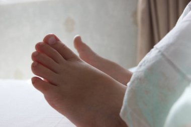 Ayaklarını yatağın üzerinde hafif bir battaniyenin altına koy. Sağlık ve yaşam tarzı kavramı