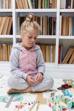 Çocuk inşaatçı tuğlalarıyla, oyuncaklarla oynar, yumuşak odaklı arka planla çalışır