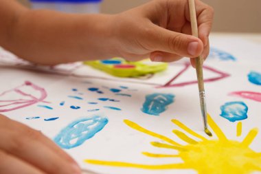 Child drawing a picture by watercolor, back to school concept