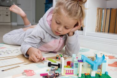 Çocuk inşaatçı tuğlalarıyla, oyuncaklarla oynar, yumuşak odaklı arka planla çalışır