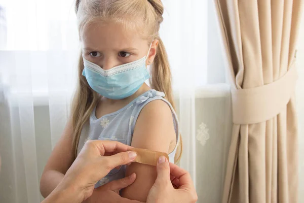 戴面具的小女孩拿着一只手臂 手上的皮肤上有石膏 疫苗接种和免疫概念 — 图库照片