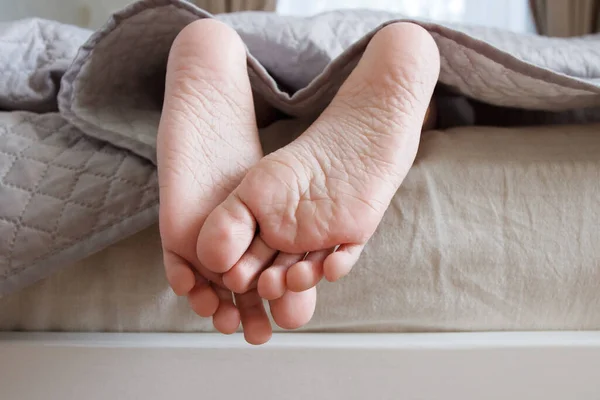 ベッドの明るい毛布の下でフィート 柔らかい焦点の背景 健康的な生活の概念 — ストック写真