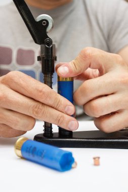 Plastik kovanı tamir eden bir adam ateş etmek ya da avlanmak için fişek yapar.