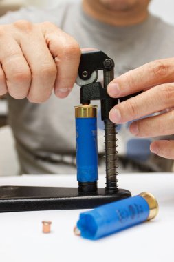 Plastik kovanı tamir eden bir adam ateş etmek ya da avlanmak için fişek yapar.