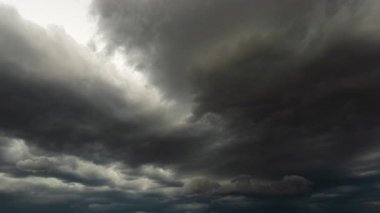 Zaman aşımına uğramış 4K görüntüleri karanlık bir gökyüzü altında fırtına bulutlarının hareket ettiğini gösteriyor. Hızlı hava değişikliklerini, çarpıcı bulut oluşumlarını ve doğanın hareketli güçlü enerjisini vurguluyor.