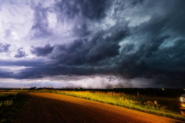 Karanlık bir fırtına bulutunun üzerinde parlayan parlak şimşekler gölge, doku ve karamsar atmosferle dolu dramatik bir gökyüzünü aydınlatıyor, doğanın gücünü ve güzelliğini gösteriyor.