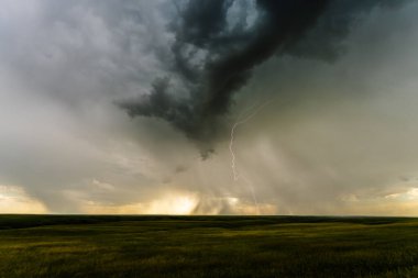 Üzerimizde şimşek çakarken kara bulutlar gelişir. Gölge, doku ve karamsar atmosferle dolu dramatik bir manzara yaratır. Fırtınanın saf gücünü, tehlikesini ve destansı güzelliğini yakalar.