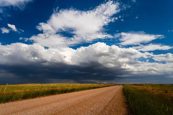 Pofuduk bulutlar sessiz çakıllı bir yolda yavaşça ilerler, yumuşak dokusu ve nazik hareketiyle huzurlu, karamsar bir gökyüzü yaratır, doğanın zarif güzelliğini ve sakin atmosferini yakalar ve yıpratır.