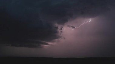 Doğanın ham gücünü ve güzelliğini gösteren sinematik fırtına görüntüleri, dönen süper hücreler, canlı şimşekler, dramatik gökyüzü altında şiddetli yağmur. Kara bulutlar ve ışık parlamaları yoğun, atmosferik bir hava göstergesi yaratır..