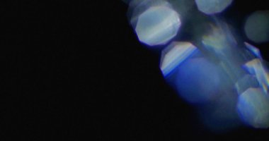 Mavi ışık sızar ve koyu arkaplanda bokeh efektleri olur. Kristal şekiller ışıldıyor.