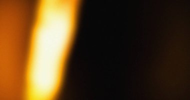 Bulanık ışık sızıntısı efekti. Koyu arkaplanda sarı ve turuncu renkler var. Film tahıl dokusu görünür..