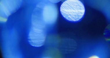 Bulanık mavi Bokeh ışıkları desenli soyut bir arkaplan oluşturur. Yumuşak odak ve canlı renk.