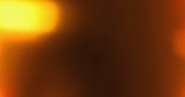 Parlak sarı ışık sızıntısı etkileri olan bulanık turuncu ve kahverengi bir arka plan. Soyut doku.