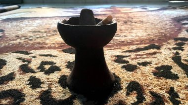 Sigara kül tablasında desenli bir halıda dinleniyor..