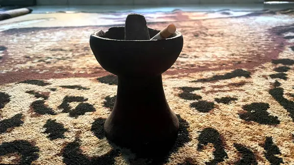 Sigara kül tablasında desenli bir halıda dinleniyor..