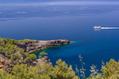 Soller, Balearic Adaları, İspanya - 13 Mayıs 2024: Turkuaz denizi ve rock noktasını turistlerle birlikte turistik bir gezi teknesi olarak görmek