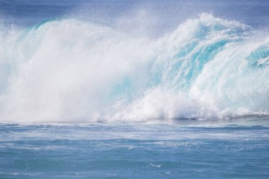 Kristal berrak turkuaz mavi su renginde dalgalar eziyor.