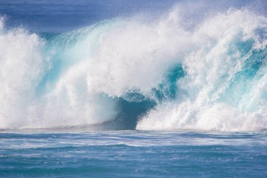 Kristal berrak turkuaz mavi su renginde dalgalar eziyor.