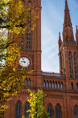 Şehir saatinin ortasında, sonbahar izinleriyle çevrili bir kilisenin saati yazdan sonbahara, sonbahardan sonbahara değişiyor.