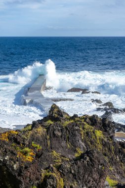 Güçlü dalgalar, Azores, Terceira Adası 'nda manzaralı bir banyo alanı olan Cinco Ribeiras kıyısı boyunca çarpışıyor..