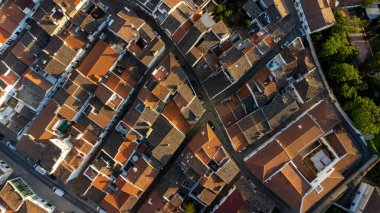 Portekiz, Evora 'nın büyüleyici tarihi caddelerinin havadan görünüşü. Parke taşlı yollar altın güneş ışığı altındaki antik binaların yanından geçiyor..