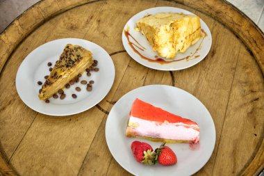 Indulge in a trio of delectable desserts: classic Portuguese biscuit cake, strawberry cheesecake, and fluffy molotov. clipart