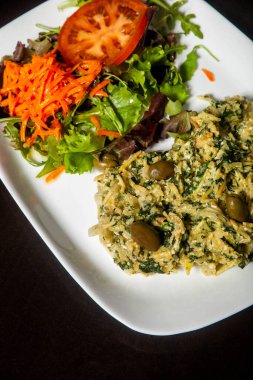 Bacalhau Brs 'a benzeyen ıspanaklı leziz morina balığı yemeği taze salatayla servis edilir. Lezzetli bir Portekiz spesiyali..