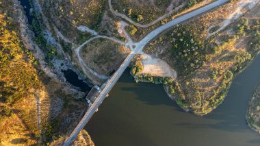 Gün batımında Vora 'daki Monte Novo Barajı' nın havadan görünüşü, sakin suları, yeşillikleri ve batan güneşin altın renklerini gözler önüne seriyor..