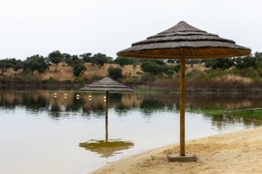 Şiddetli kış yağmurları nedeniyle Alqueva Barajı 'ndaki Azenhas DelRei plajında saman güneş gözlüğü neredeyse tam kapasite su altında kaldı..