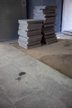 Kısmen tamamlanmış bir zemin mozaiği, bir tarafında düzgün yerleştirilmiş fayanslar, diğer tarafında yerleştirilmemiş fayanslar, tadilatta olan yenileme çalışmalarını yakalıyor..