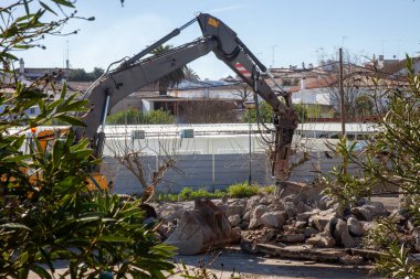 Bina yenileme projesi sırasında ağır hidrolik çekiçle taş kırılıyor. İnşaat ve yıkım için ideal stok fotoğrafçılığı.
