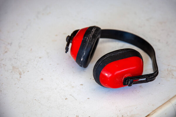 Высоковидимая защита уха, лежащая на земле на строительной площадке, подчеркивая безопасность оборудования для рабочих.