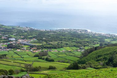 Asor 'ların yemyeşil alanları, temiz bir gökyüzünün altında düzgün dikdörtgen şekiller oluşturan taş duvarlarla bölünmüş. Adaların doğal güzelliğini ve eşsiz tarımını gösteren sakin bir manzara..