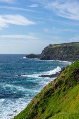 Atlantik Okyanusu dalgaları, Portekiz, Azores, Terceira Adası 'nın engebeli kıyı şeridinde volkanik kayalara çarpıyor..