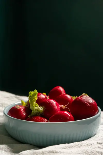 stock image Fresh radishes in a bowl with soft lighting, showcasing their vibrant colors and crisp texture. Ideal for food-related content and healthy lifestyle themes.