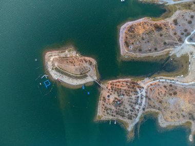 Portekiz, Alentejo 'daki Mouro Nehri plajının hava manzarası. Alqueva rezervuarının yanında, kumlu kıyılar, sakin sular ve rahatlama ve açık hava aktiviteleri için ideal manzara güzelliği sunuyor..