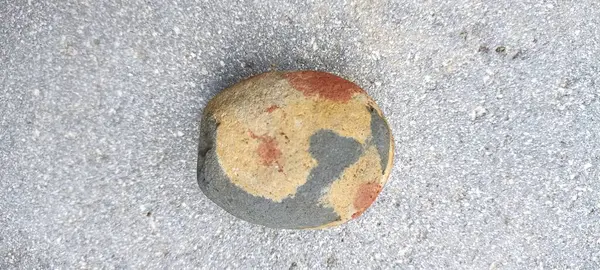Gri ve açık kahverengi renkli küçük bir taş.