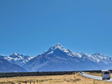 Yeni Zelanda 'nın Güney Adası' ndaki güzel doğa manzarası için Cook Dağı 'na giden yolda kiralık karavanla seyahat eden turistler.