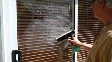 Bir konservatuarın camına sünger uygulayıcısı ile sabun uygulamak