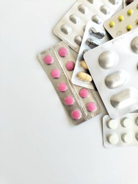 Kabarcıklardaki tabletler. Beyaz arka planda ilaçlar. Çeşitli haplar ve vitaminler. Tıp ve sağlık hizmetleri kavramı.
