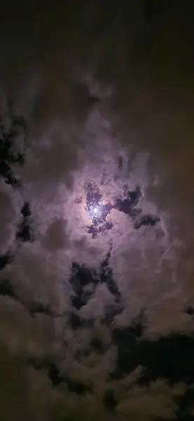 Moon among the clouds in the night sky