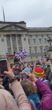 Kraliyet ailesi, Buckingham Sarayı 'ndaki taç giyme töreninden sonra bir balkonda toplanıp tezahürat yapan insanları selamlıyor.