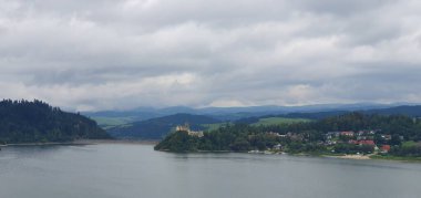 Czorsztyn Reservoir Panoraması Czorsztyn Kalesi manzaralı. Bulutlu gökyüzü, su ve ormanlar. Baraj perspektifinden bak.
