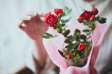 Pencerenin yanında karanfilli kadın