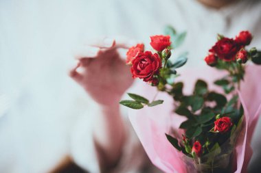 Pencerenin yanında karanfilli kadın