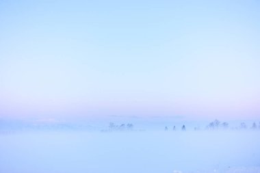 Kışın gün doğumu ve soğuk sis