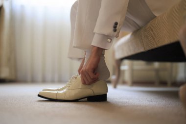 Düğünde ayakkabı giyen adam.