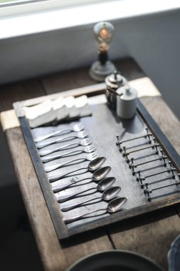 Antika kaşıklar ve çatallar dizilmiş.